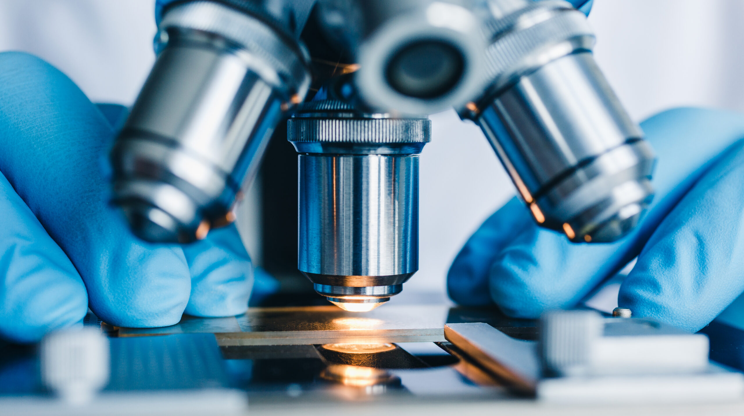 High school student working on a STEM passion project for college admissions, examining a sample under a microscope as part of sustained original research.