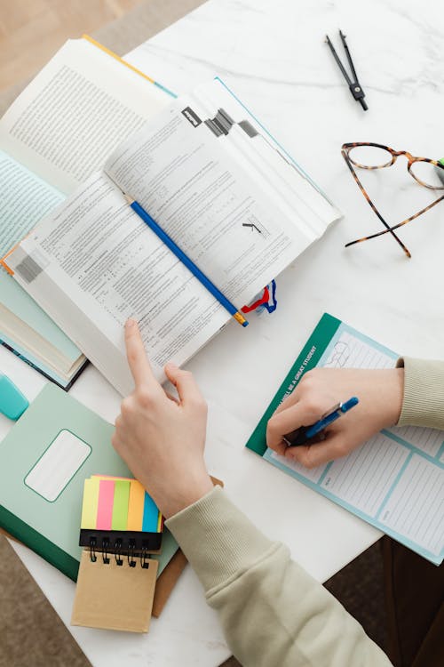 Student studying with open textbooks and notes for Columbia University GPA requirements