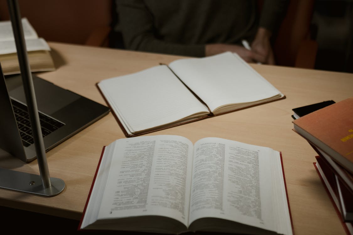 Open notebooks and textbooks on a study desk for Cornell University GPA requirements