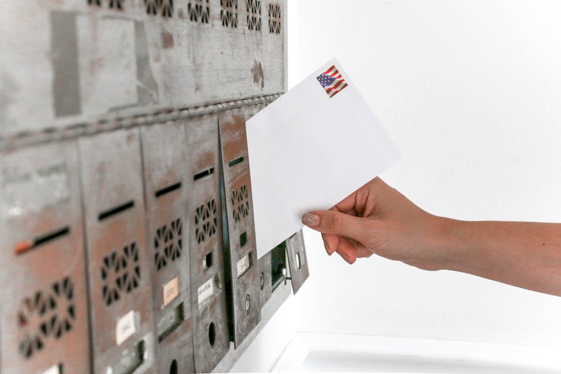 Hand placing envelope in mailbox representing waiting for Emory waitlist decision