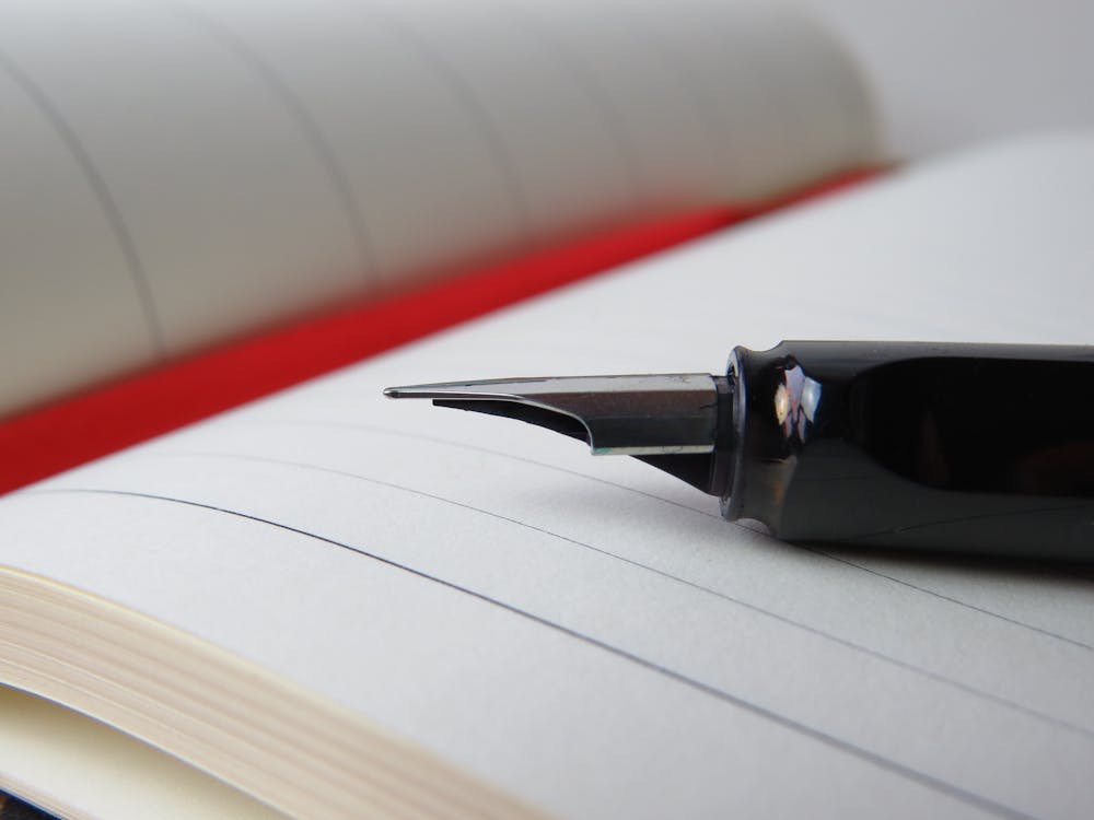 Fountain pen on open notebook representing Tulane University admissions essay strategy
