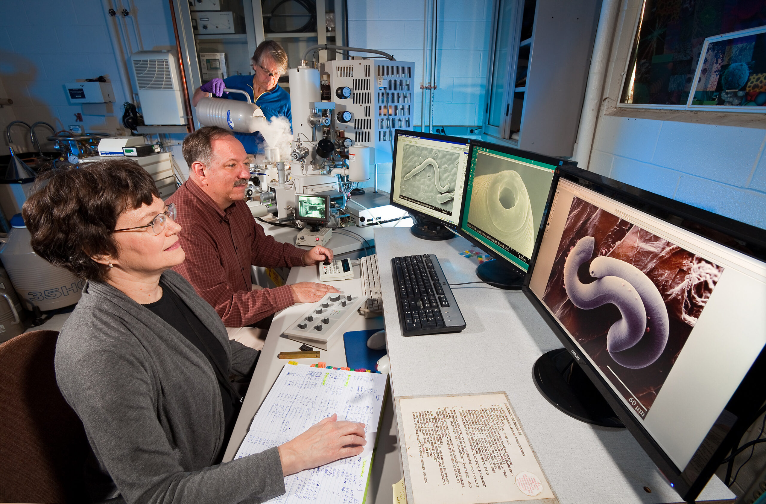 Scientists working with an electron microscope representing Regeneron STS research